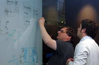 On an opaque glass wall beside a group of co-workers (out of picture), Chris Tavares maps out ideas with Alejandro Jack, an advisor from SouthWorks.