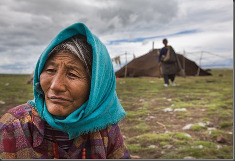 Manzong 63-- and her husband (Tele, 63-- in background) are goat herders. They have 3 daughters and 1 son. 